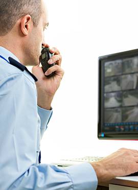 מאבטח צופה במצלמות אבטחה בבנייני מגורים