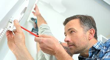 איש מתקין אינטרקום בשער